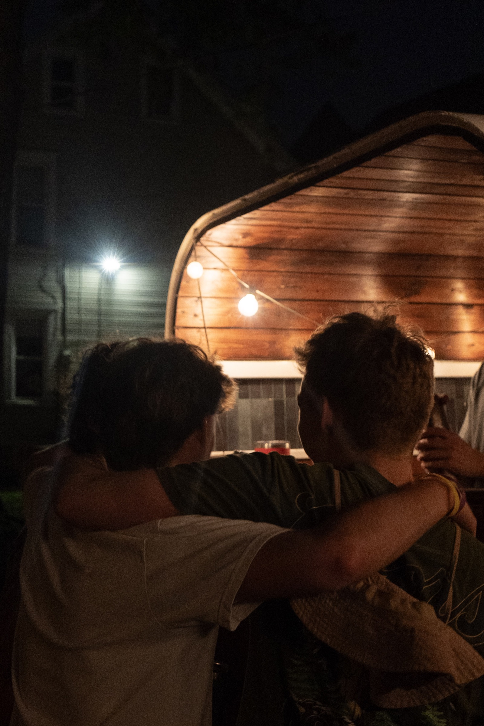 Guests at the bar trailer under string lights at night